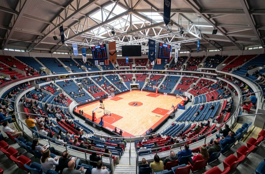 Vue panoramique de l'Accor Arena Paris depuis les gradins supérieurs lors d'un événement sportif, montrant le plan de salle complet avec les rangées de sièges colorés et le parquet central