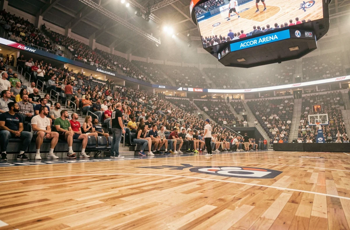 Vue depuis le bord du parquet central de l'Accor Arena Paris montrant les gradins remplis de spectateurs lors d'un match sportif